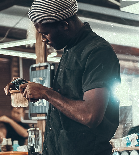 "a picture of a black barber cleaning his clippers"